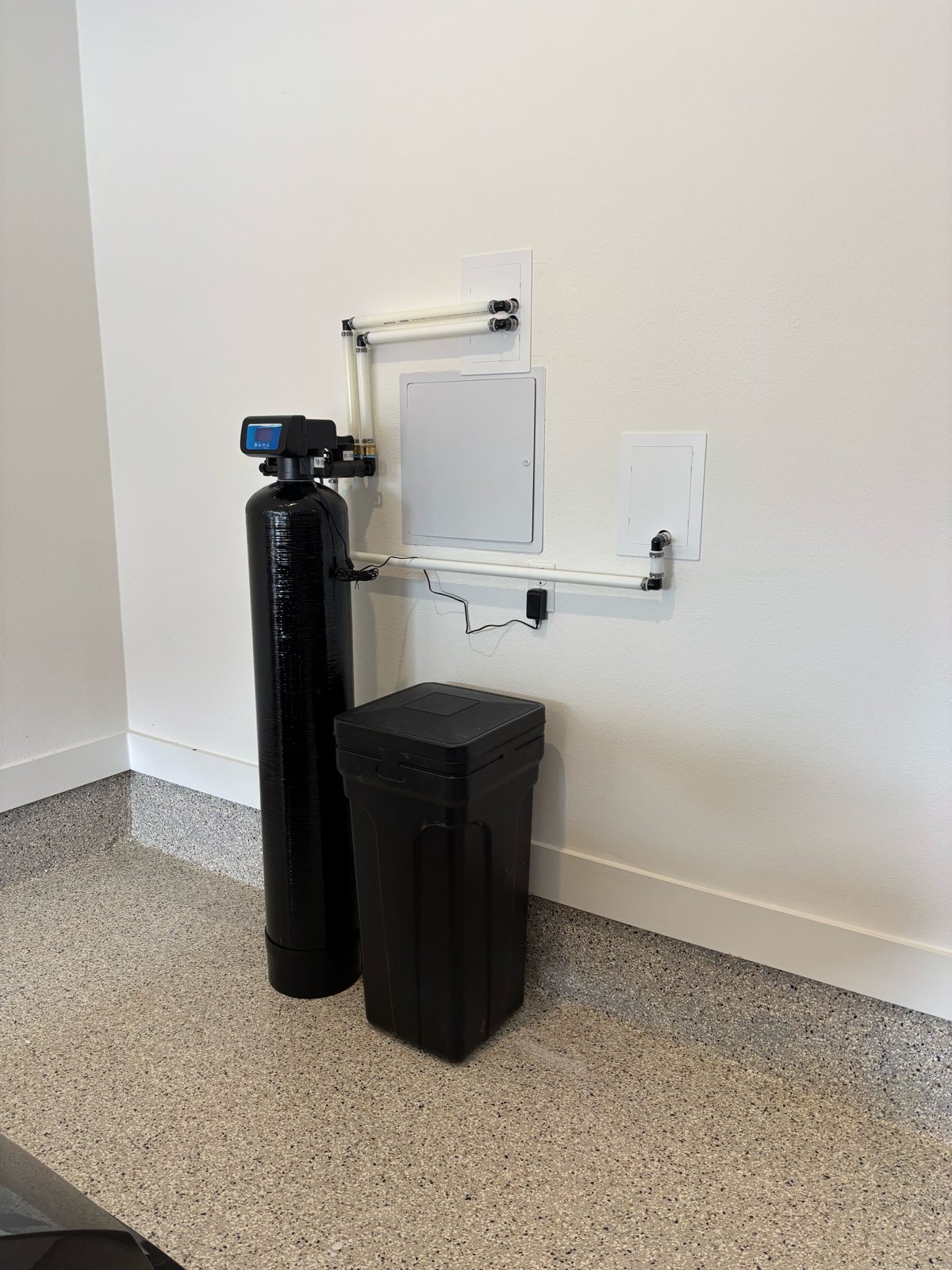 Single-tank water softener and brine tank installed by H2Ome in a garage